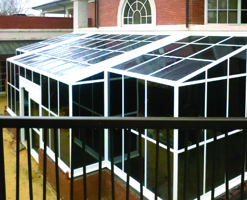 Glass solarium off the back of a brick building